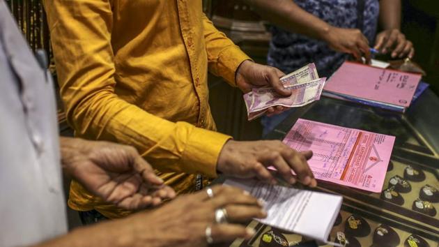 An employee holds rupee banknotes inside a jewellery store. Retailers are seeking out more lighter-weight jewellery to boost sales, while soaring prices have prompted some people to prefer giving gift vouchers instead of gold for weddings, said Raju Solanki, owner of a Zaveri Kapoorchand Lalchand store in Mumbai. (Dhiraj Singh / Bloomberg)