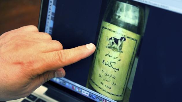 Bruce Khabbazi points to an image of an original bottle of ‘Arak Saggi’, or Doggy Arak, that was produced in Iran in the 1950s. Born in Shiraz to a family with more than 125 years in the food industry, Khabbazi fled Iran at age 16 to avoid fighting in the Iran-Iraq war and because he said he saw no future for young Iranians after the revolution. In Canada, he changed his name from Behrouz to Bruce. (Kamran Jebreili / AP)
