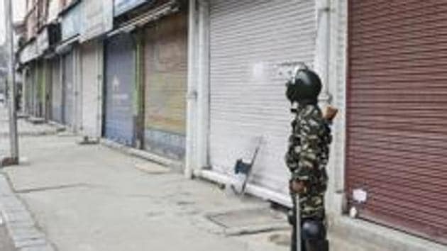 A security person stands guard during shutdown in Srinagar. (PTI Photo) A security person stands guard during shutdown in Srinagar. (PTI Photo)