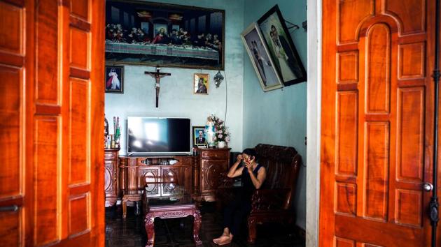Hoang Thi Ai, 48, mother of Hoang Van Tiep, one of the suspected victims, talks with a relative on the phone about the situation of her son, at her house, in Dien Chau district, Nghe An province. However they migrants arrive in Europe, stowing away on a container truck is the only way to take that final step across the Channel, migrants and anti-trafficking experts said. (Athit Perawongmetha / REUTERS)