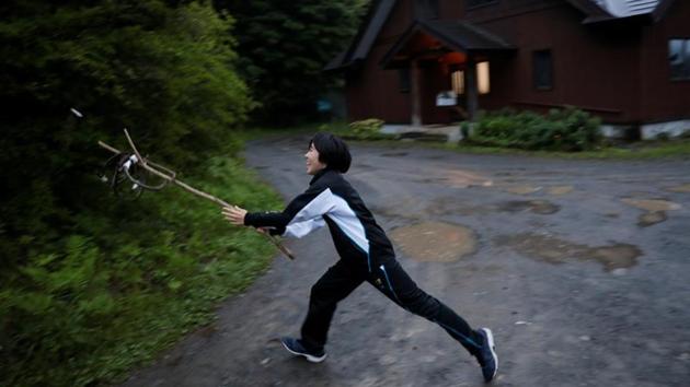 Yumeka, a son of Ainu hunter Atsushi Monbetsu, plays Karippekap an Ainu folk game, with his father (not pictured) in Biratori. Ainu children are half as likely to go to college as other Japanese and average household earnings are significantly lower, official data show. (Kim Kyung-Hoon / REUTERS)