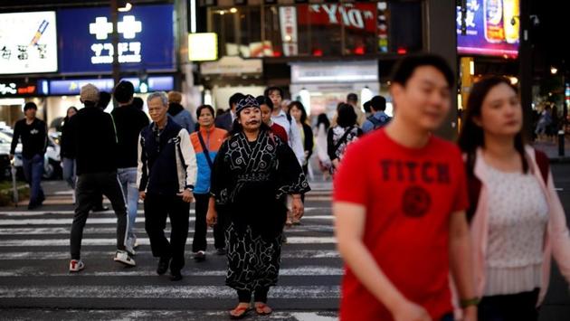 Mai Hachiya in traditional Ainu attire as she walks downtown in Sapporo. Hachiya, 36, who is also a singer, has been asked to practice a routine with other Ainu performers that may be included in the Olympics opening ceremony. “I think Hokkaido is a Japanese colony,” she said. “That’s a hard thing to say, but if you look back on what was done, that’s what you have to conclude.” (Kim Kyung-Hoon / REUTERS)