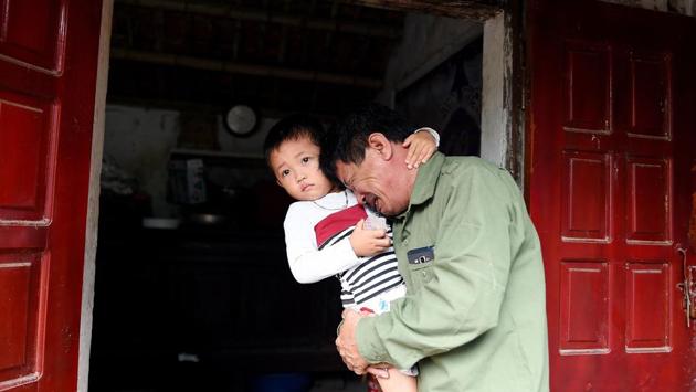 Le Minh Tuan, father of 30-year old Le Van Ha, feared to be among the 39 people, cries while holding Ha’s son outside their house in Nghe An province. “Parents pay for the ‘VIP’ service because they think it’ll be safer but what they don’t realise is that their son or daughter will end up in the same container truck as someone who paid for the cheap journey,” said Vu. (Nhac Nguyen / AFP)