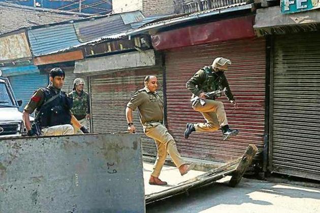 A policeman jumps as his officer kicks to remove a road block put up by protesters in Srinagar. (AP PHOTO) A policeman jumps as his officer kicks to remove a road block put up by protesters in Srinagar. (AP PHOTO)