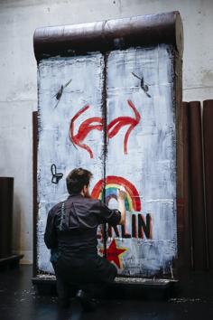 French chocolate maker Patrick Roger's creative assistant Angelo Dao works at a chocolate reproduction of the Berlin wall, in Sceaux, outside Paris, Wednesday, Oct. 30, 2019. The creation was made to mark the upcoming 30th anniversary of the fall of the Berlin Wall and will be destroyed on Nov.9. (AP Photo/Kamil Zihnioglu) (AP)