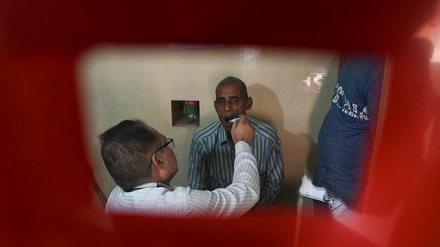 A doctor checks a suspected tuberculosis (TB) patient at a DOTS (directly observed treatment, short-course) Centre in New Delhi. In a trial in three African nations, GlaxoSmithKline said its new vaccine had 50 percent effectiveness three years after it was given to participants who already have TB bacteria but have not fallen ill from the disease. (Money Sharma / AFP)