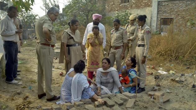 The kin of slain gangster Vijay Sidhu, alias Chhota Lalla, trying to exhume his body from the grave at a cemetery at Peeru Banda of Salem Tabri in Ludhiana on Thursday.(HT PHOTO)