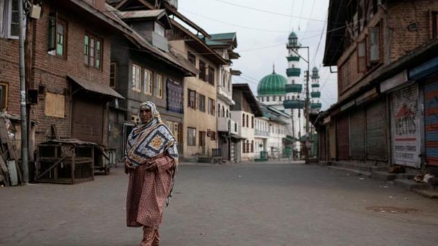 A Kashmiri woman walks through an empty street in Anchar neighbourhood, during restrictions following the scrapping of special status of Jammu and Kashmir.(REUTERS)