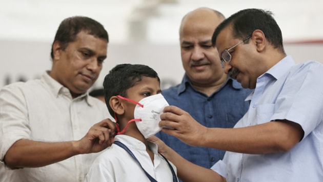 Delhi chief minister Arvind Kejriwal distributing mask to a school student at an event in New Delhi on November 1, 2019.(Sanchit Khanna / HT Photo)