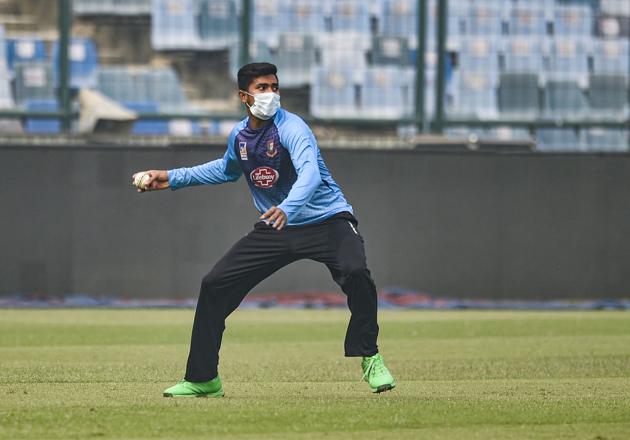 Bangladeshi cricketer Soumya Sarkar, wearing a mask, throws the ball during a practice session at Arun Jaitley Stadium in New Delhi. (PTI)