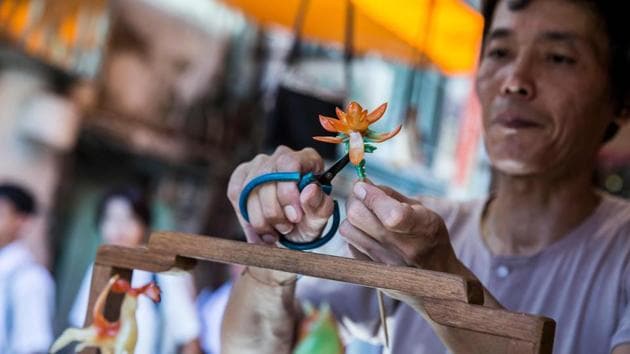 Louis To makes a flower out of candy at his shop. To’s shop on Cheung Chau, a small island in the waters west of Hong Kong’s famous Victoria Harbour, has become a must-see for visiting tourists. There they can watch a man locals dub “The Candyman” sculpt sugar into a host of animals and fantastical creatures. (Isaac Lawrence / AFP) Louis To makes a flower out of candy at his shop. To’s shop on Cheung Chau, a small island in the waters west of Hong Kong’s famous Victoria Harbour, has become a must-see for visiting tourists. There they can watch a man locals dub “The Candyman” sculpt sugar into a host of animals and fantastical creatures. (Isaac Lawrence / AFP)