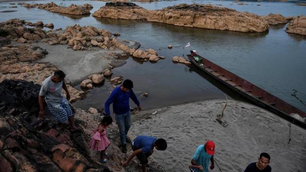 Thai tourists along the banks of the Mekong in the Thai province of Nong Khai, with Laos in the background. Experts say the dam-building frenzy in China and Laos has compounded the drought. “These are causing the Mekong to die a death of a thousand cuts,” said Brian Eyler, author of ‘The Last Days of the Mighty Mekong.’ “Some parts of the river (have) hit historic lows for any time of the year.” (Lillian Suwanrumpha / AFP)