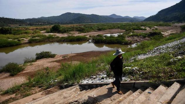 A fisherwoman walks on an embankment of the Mekong River in Pak Chom district in the Thai province of Loei. Along parts of this border province, the kilometre wide river has shrivelled to a few dozen metres, with boulders and bedrock encasing muddy pools of water. (Lillian Suwanrumpha / AFP)