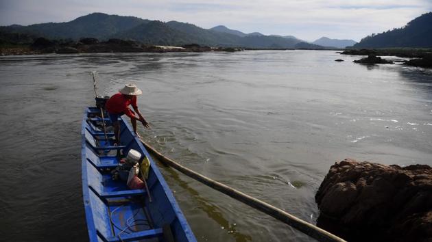 “I don’t want any more dam construction,” said fisherman Sup Aunkaew, who tossed a meagre catch into his boat, adding that the fish spawning habits have been “confused” by the unseasonally low water levels. “But we can’t really oppose their plans if they want to do it.” (Lillian Suwanrumpha / AFP)
