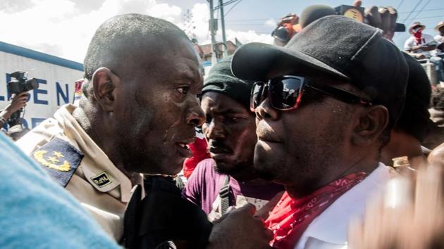 Petion-Ville’s Police chief Paul Menard (L) has a discussion with a protester as police officers and their supporters protest for better salaries for law enforcement, as anti-government marchers also took to the streets in Port-au-Prince, Haiti. (Valerie Baeriswyl / AFP) Petion-Ville’s Police chief Paul Menard (L) has a discussion with a protester as police officers and their supporters protest for better salaries for law enforcement, as anti-government marchers also took to the streets in Port-au-Prince, Haiti. (Valerie Baeriswyl / AFP)