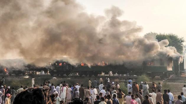 Residents gather beside the burnt-out train carriages after a passenger train near Rahim Yar Khan, Pakistan. At least 74 people were killed in a fire that engulfed three carriages of the train after a gas canister passengers were using to cook breakfast exploded, triggering the worst disaster on Pakistan’s railway system in nearly 15 years. (Pakistan’s Punjab Emergency Service Rescue 1122 / AFP) Residents gather beside the burnt-out train carriages after a passenger train near Rahim Yar Khan, Pakistan. At least 74 people were killed in a fire that engulfed three carriages of the train after a gas canister passengers were using to cook breakfast exploded, triggering the worst disaster on Pakistan’s railway system in nearly 15 years. (Pakistan’s Punjab Emergency Service Rescue 1122 / AFP)