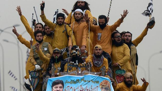 Supporters of the Islamist Jamiat Ulema-e-Islam (JUI-F) wave party flags atop a vehicle as they take part in an anti-government “Azadi (Freedom) March” towards Islamabad, from Peshawar, Pakistan. (Abdul Majeed / AFP) Supporters of the Islamist Jamiat Ulema-e-Islam (JUI-F) wave party flags atop a vehicle as they take part in an anti-government “Azadi (Freedom) March” towards Islamabad, from Peshawar, Pakistan. (Abdul Majeed / AFP)