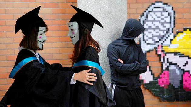 University students wearing Guy Fawkes masks pose for a photoshoot of a graduation ceremony to support anti-government protests at the Hong Kong Polytechnic University, in Hong Kong. (Tyrone Siu / REUTERS) University students wearing Guy Fawkes masks pose for a photoshoot of a graduation ceremony to support anti-government protests at the Hong Kong Polytechnic University, in Hong Kong. (Tyrone Siu / REUTERS)