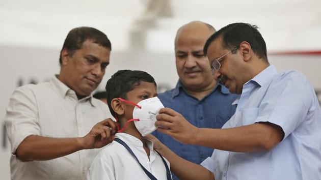 Delhi Chief Minister Arvind Kejriwal and Delhi Deputy Chief Minister Manish Sisodia seen helping a student as he puts on a mask, at Rajkiya Pratibha Vikas Vidyalaya, Civil Lines, in New Delhi.(Sanchit Khanna/HT PHOTO)