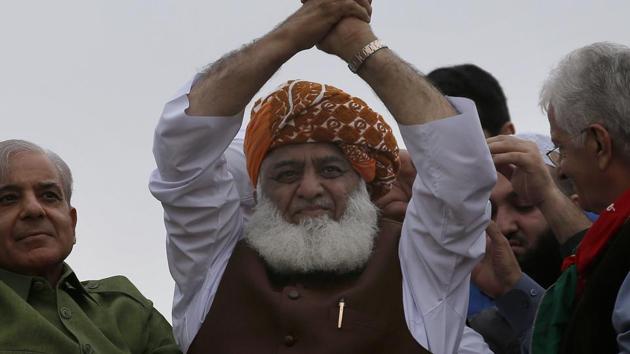 Radical cleric and leader of Islamist party 'Jamiat Ulema-e-Islam' Maulana Fazlur Rehman, center, waves to his supporters during an anti-government march, in Islamabad.(AP photo)