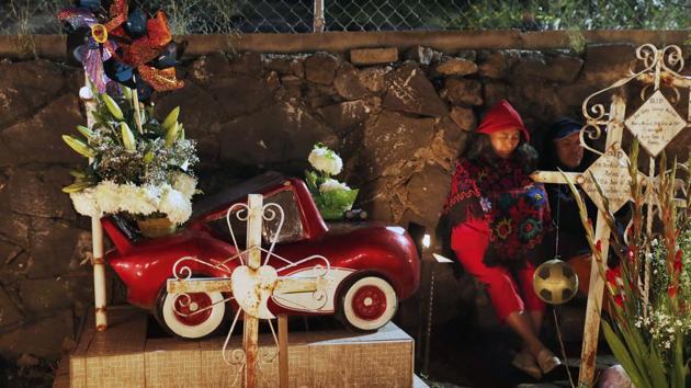 Relatives spend the night next to a child's tomb in the San Gregorio Atlapulco cemetery during Day of the Dead festivities on the outskirts of Mexico City, Friday, Nov. 1, 2019. In a tradition that coincides with All Saints Day and All Souls Day, families decorate the graves of departed relatives with flowers and candles, and spend the night in the cemetery, eating and drinking as they keep company with their deceased loved ones.  (AP) 