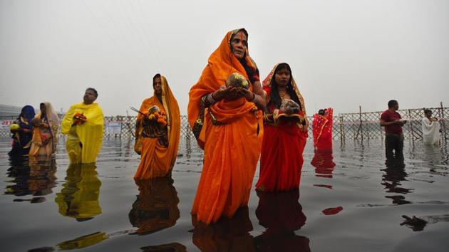 Devotees on the banks of the Yamuna River in an enclosed area while performing rituals and prayers on the occasion of Chhath Puja at Yamuna Ghat, in New Delhi. (Sanchit Khanna / HT Photo)