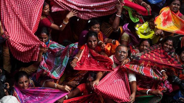 Hindu devotees collect rice as offerings distributed by the temple authority on the occasion of the ‘Annakut’ or ‘Govardhan Puja’ festival at the Madan Mohan temple in Kolkata, West Bengal. (Dibyangshu Sarkar / AFP)