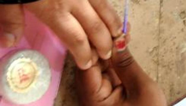 Election duty staff ink marks a voter's finger at a poling booth in Bangalore during the Karnataka Assembly Election. (UNI Photo)