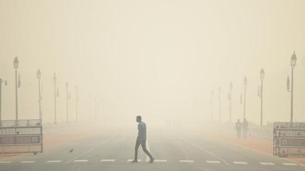 A man walks past India Gate engulfed with dense smog, at Rajpath, in New Delhi. Post Diwali celebrations and on-going crop burning in neighboring states, the air quality in the national capital has deteriorated severely. (Biplov Bhuyan / HT Photo)