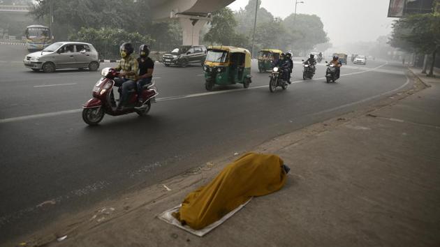 A man sleeps next to a road amid running traffic, thus exposing oneself to deadly pollutants. “The best solution for the people on the streets would be to relocate them to less polluted areas, away from traffic junctions,” said TK Joshi, environmental health advisor to the central government. (Biplov Bhuyan / HT Photo) A man sleeps next to a road amid running traffic, thus exposing oneself to deadly pollutants. “The best solution for the people on the streets would be to relocate them to less polluted areas, away from traffic junctions,” said TK Joshi, environmental health advisor to the central government. (Biplov Bhuyan / HT Photo)