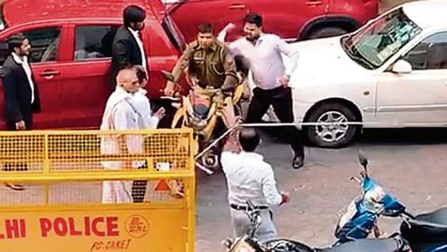A group of advocates pushes down a police post signboard outside Saket district court; Lawyers thrash a man who was seen filming lawyers breaking the signboard; a policeman in uniform is cornered, slapped repeatedly and elbowed. (Screen grabs) A group of advocates pushes down a police post signboard outside Saket district court; Lawyers thrash a man who was seen filming lawyers breaking the signboard; a policeman in uniform is cornered, slapped repeatedly and elbowed. (Screen grabs)