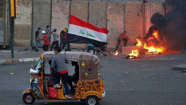 Protesters set fire while security forces fired live ammunition and tear gas near the state-run TV in Baghdad. Security forces have fired tear gas and rubber bullets to keep them away from barricades on the nearby Al-Joumhouriyah and Al-Sanak Bridges, but they appear to have broken through on the Al-Ahrar Bridge further north on the Tigris River. (AP Photo)