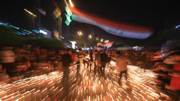 Iraqi protesters hold a candlelight vigil for victims killed during ongoing anti-government demonstrations in the Shiite shrine city of Karbala. Political leaders have expressed sympathy for the protesters’ demands while condemning acts of violence on all sides and calling on the protesters to stop disrupting daily life. (Mohammed SAWAF / AFP)