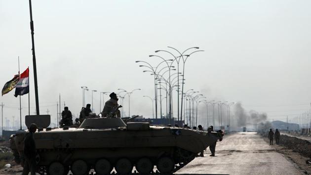 Iraqi army forces guards at the entrance of Umm Qasr Port as protesters block the road. Tens of thousands of Iraqis have demonstrated in central Baghdad and across mostly Shiite southern Iraq in recent days, calling for the overthrow of the political system. The protests are fueled by anger at widespread corruption, high unemployment and poor public services. (Essam al-Sudani / REUTERS)