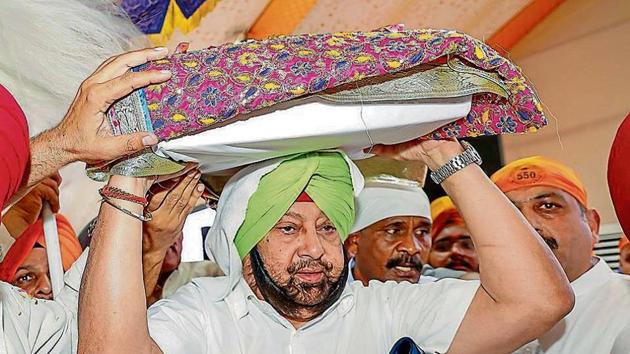 Punjab chief minister Capt Amarinder Singh carrying the Guru Granth Sahib as he launched the week-long celebrations in Sultanpur Lodhi on Tuesday.(HT Photo)