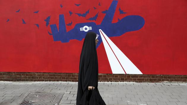 A woman walks past a new anti-U.S. mural on the wall of former U.S. embassy portraying the interception of Global Hawk US drone by Iran in Persian Gulf, after an unveiling ceremony in Tehran. (AP)
