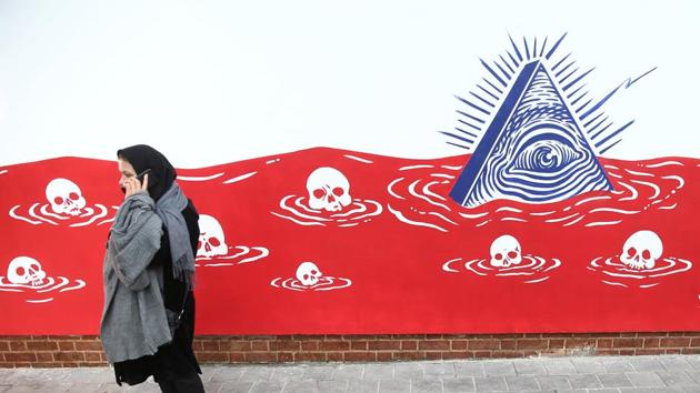 A woman walks in front of new murals of the former US embassy in Tehran. Anti-U.S. works of graphics is the main theme of the wall murals painted by a team of artists ahead of the 40th anniversary of the takeover of the U.S. diplomatic post by revolutionary students. (VIA REUTERS)
