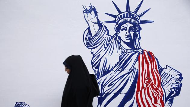 A woman walks in front of new murals of the former US embassy in Tehran, Iran November 2, 2019. (VIA REUTERS)