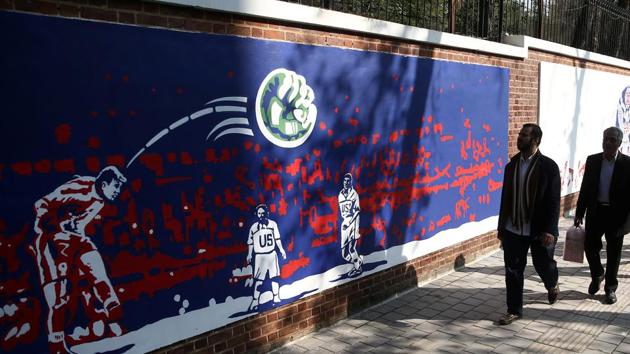 People walk in front of new murals of the former US embassy in Tehran, Iran. (VIA REUTERS)