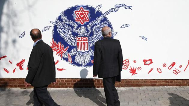 People walk in front of new murals of the former US embassy in Tehran, Iran. (VIA REUTERS)