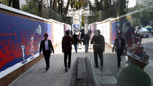 People walk in front of new murals of the former US embassy in Tehran, Iran November 2, 2019. (VIA REUTERS)