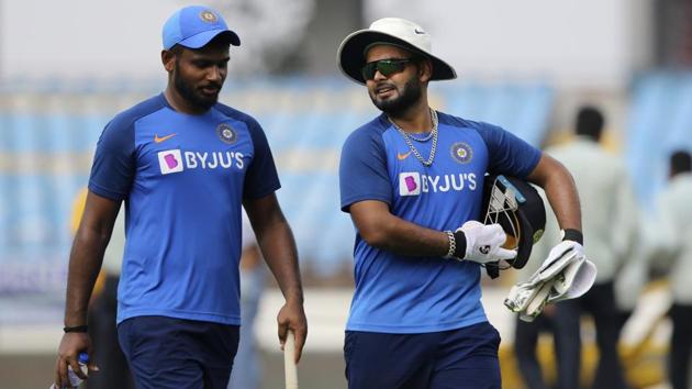 Indian players Rishabh Pant, right and Sanju Samson return after a practice session.(AP)