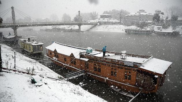 A boatman clears snow from his boat, in Srinagar. According to private weather agency SkymetWeather, due to heavy snowfall in Jammu and Kashmir and Himachal Pradesh, icy cold northerly winds from the hills will bring down the minimum temperatures in Punjab, Haryana, north Rajasthan and Delhi from November 9. (ANI)