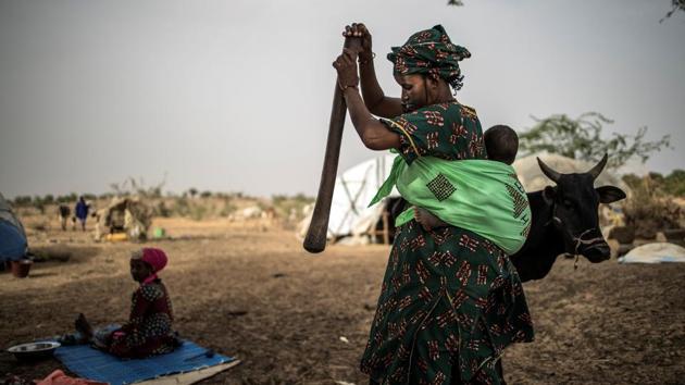 A Fulani woman pounds away in a mortar in an informal camp in Banguetaba. The deep poverty and isolation of the Fulani people have made many vulnerable to the siren call of the jihad -- an appeal that today is disseminated at lightning speed on WhatsApp and Facebook. (Marco Longari / AFP)