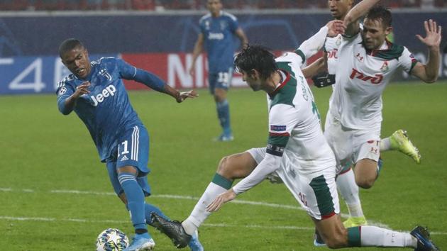 Juventus' Douglas Costa, left, fights for the ball with Lokomotiv's Vedran Corluka during the Champions League Group D soccer match between Lokomotiv Moscow and Juventus at the Lokomotiv Stadium in Moscow, Russia, Wednesday, Nov. 6, 2019.(AP)