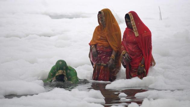 Devotees perfrom rituals in the polluted waters of Yamuna river at Kalindi Kunj on the occasion of Chhath Puja. Recently, scores of helpless devotees were forced to offer prayers to the sun god by immersing themselves in the toxic foam present inside the river Yamuna during the 4-day long Chhath Puja festival. (Sunil Ghosh / HT Photo)