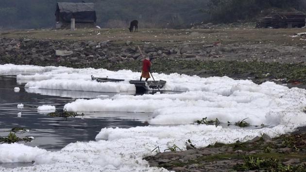 A boatman wades his boat through layers of toxic foam. Cleaning of Yamuna is also part of the Namami Gange Mission and Government of India has been supplementing the efforts of the states for checking the rising level of pollution of river Yamuna, a tributary of River Ganga, by providing financial assistance to states of Haryana, Delhi and Uttar Pradesh in phased manner since 1993 under the Yamuna Action Plan (YAP). (Mohd Zakir / HT Photo)