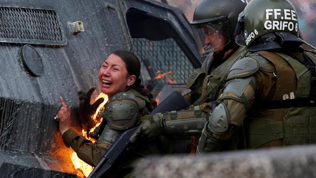 A riot police officer on fire reacts during a protest against Chile’s government in Santiago, Chile. (Jorge Silva / REUTERS)