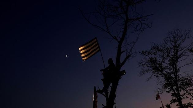 A supporter of religious and political party Jamiat Ulema-i-Islam-Fazal (JUI-F) sits in a tree holding a party flag as he listens to the speeches of leaders during what participants call Azadi March (Freedom March) to protest against the government of Prime Minister Imran Khan in Islamabad, Pakistan. (Akhtar Soomro / REUTERS)