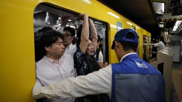 A station attendant watches as a commuter struggles to squeeze himself into an overcrowded train during morning rush hours at Akasaka Mitsuke Station. Tokyo transport officials characterise train cars at 200% capacity give passengers just enough space to read a magazine. This probably represents a normal commuting weekday in Tokyo. At 250%, they “cannot even move a hand.” (Jae C. Hong / AP) A station attendant watches as a commuter struggles to squeeze himself into an overcrowded train during morning rush hours at Akasaka Mitsuke Station. Tokyo transport officials characterise train cars at 200% capacity give passengers just enough space to read a magazine. This probably represents a normal commuting weekday in Tokyo. At 250%, they “cannot even move a hand.” (Jae C. Hong / AP)